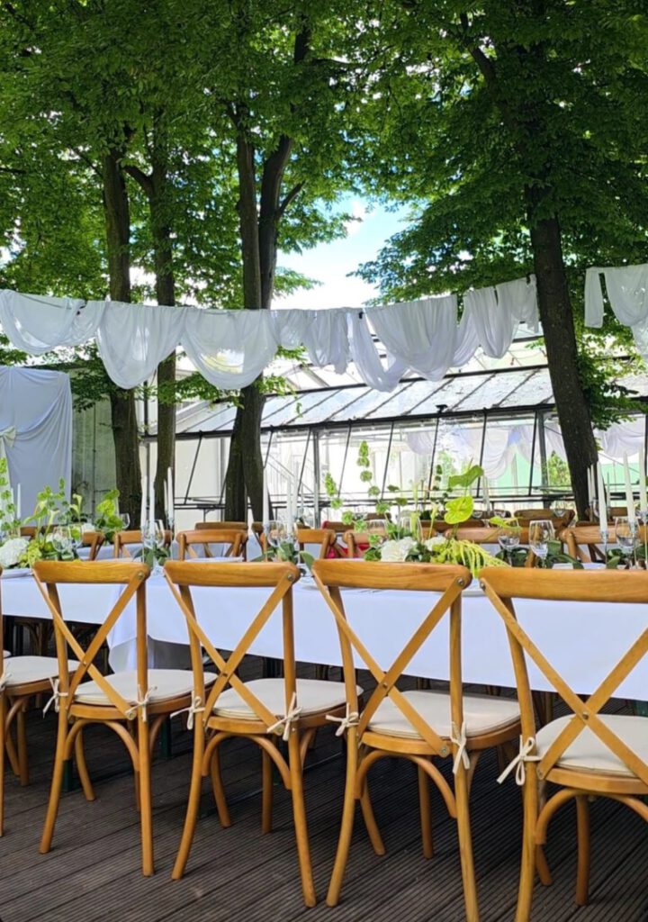 Crossback-Stühle an einer Hochzeitstafel im Freien