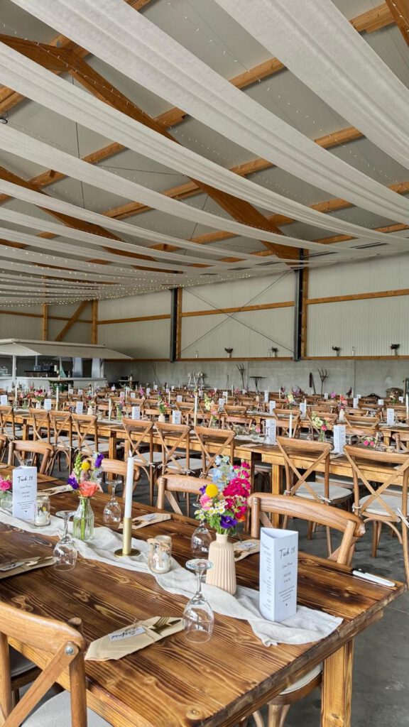 Festhalle mit Holztischen und Crossback-Stühlen