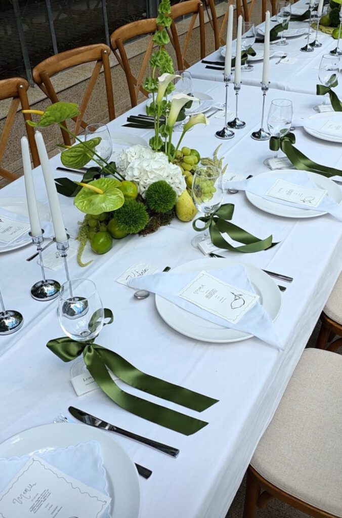 Hochzeitstafel mit Kerzenleuchtern und grünen Schleifen
