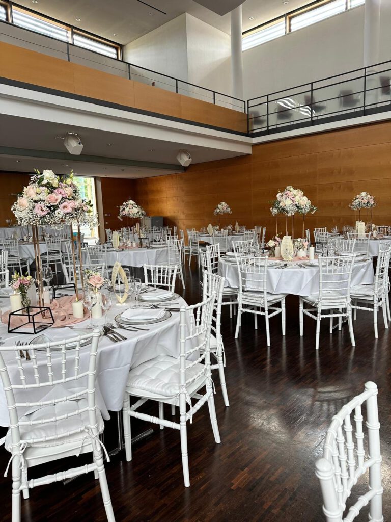 Runde Tische mit weißen Chiavari-Stühlen im Festsaal